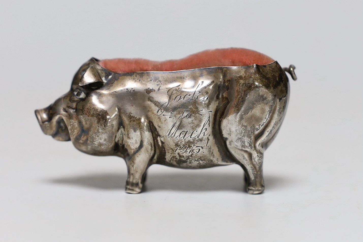 A George V silver mounted pig pin cushion, H?, Birmingham, 1912, length 77mm.